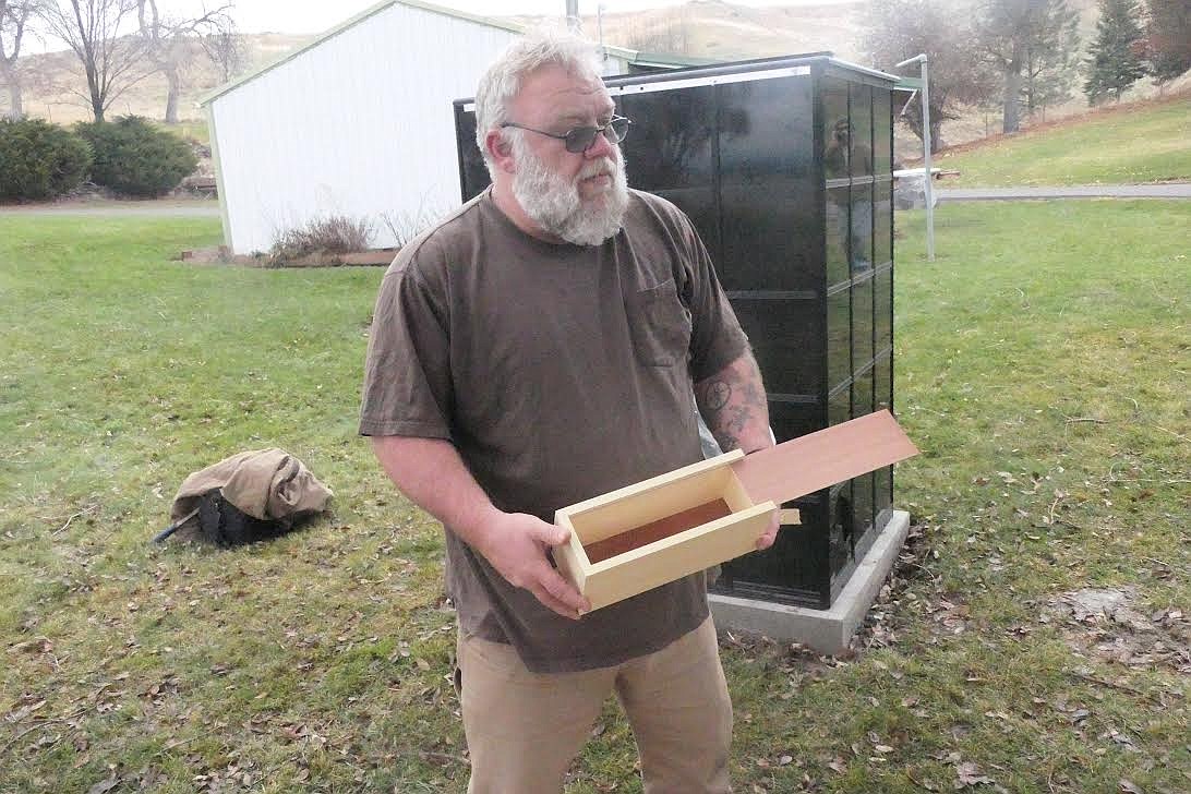 Joint Operations Mariposa member Dave Williams with a box in which ashes will be placed, then put inside the columbarium in the background at Plains Cemetary. (Chuck Bandel/Valley Press)