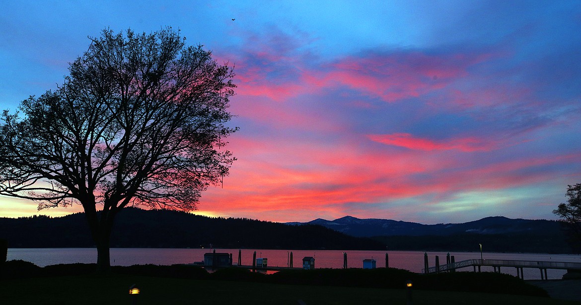 The setting sun casts a glow in the clouds over Lake Coeur d'Alene on Friday.