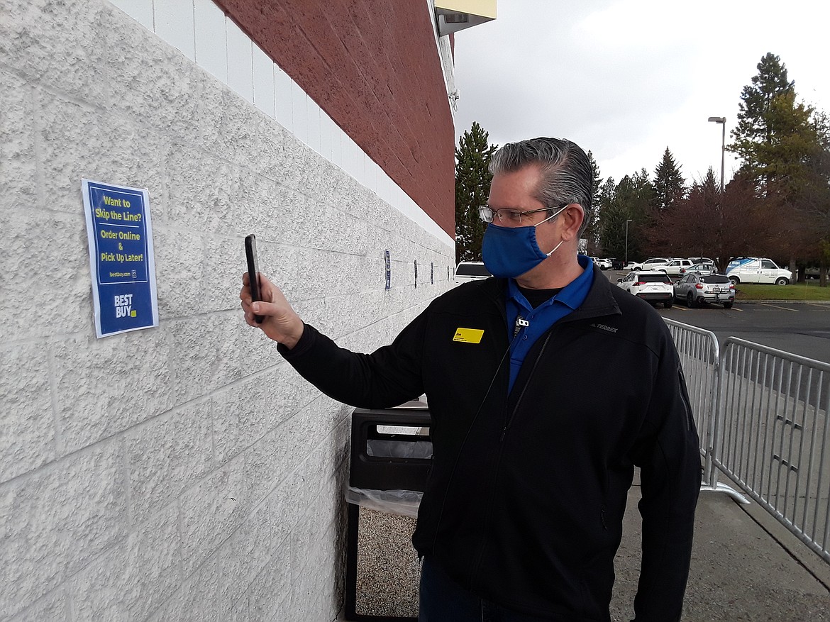 Jon Olson, general manager of the Coeur d'Alene Best Buy, demonstrates how shoppers waiting in line this Black Friday can scan a QR code to continue their shopping experience online. Olson said that safety has taken an unprecedented priority in the retail business this holiday season because of COVID-19.