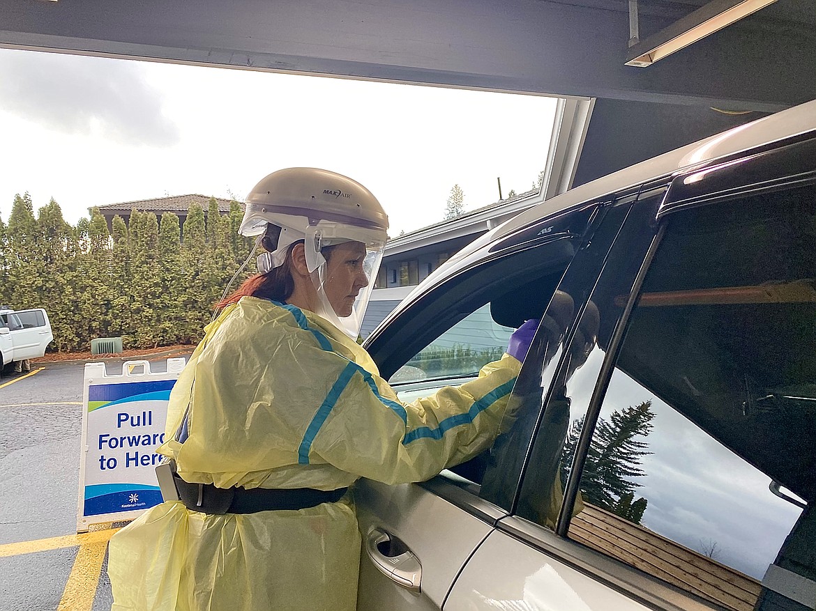Stacy Wood CMA executes a NP swab test for a COVID-19 drive-thru patient. Wearing head-to-toe PPE, Wood is using a N-99 mask-cap which is known as one of the safest face coverings available in the health industry. (MADISON HARDY/Press)