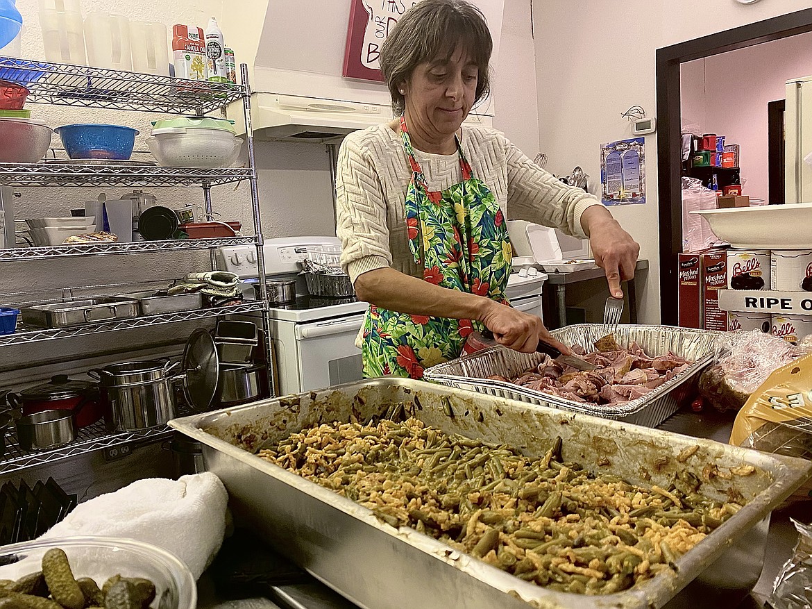 Lita Whitehead was just one of many cooks for the Cherished Ones Soup Kitchen Thanksgiving meal. Here, she is cutting up ham for the hundreds of to-go, delivery, and dine-in meals offered for the homeless and in need. (MADISON HARDY/Press)