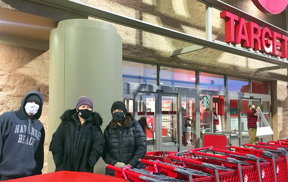 Jesse and Ammie Withnell of Coeur d’Alene, left, and Kara Fredekind wait for Target to open Friday morning.