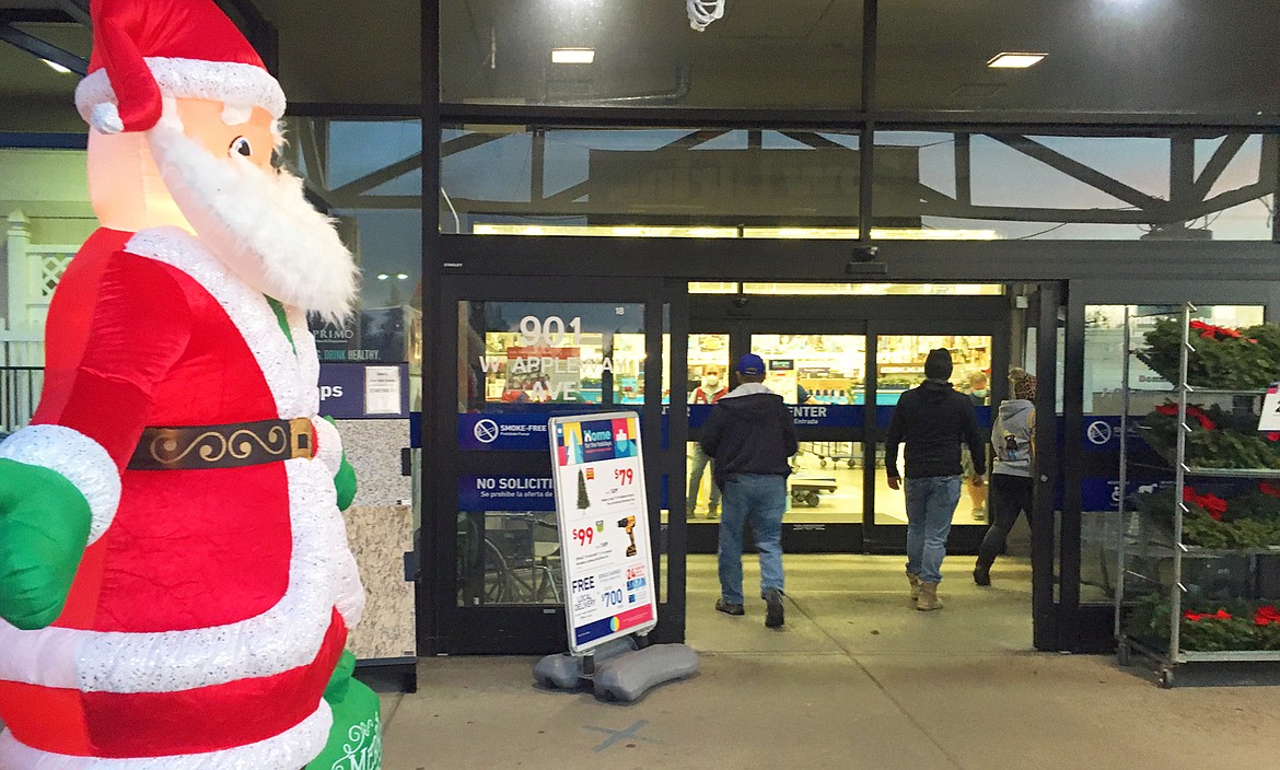 Shoppers pass by Santa on their way into Lowe's on Friday morning.