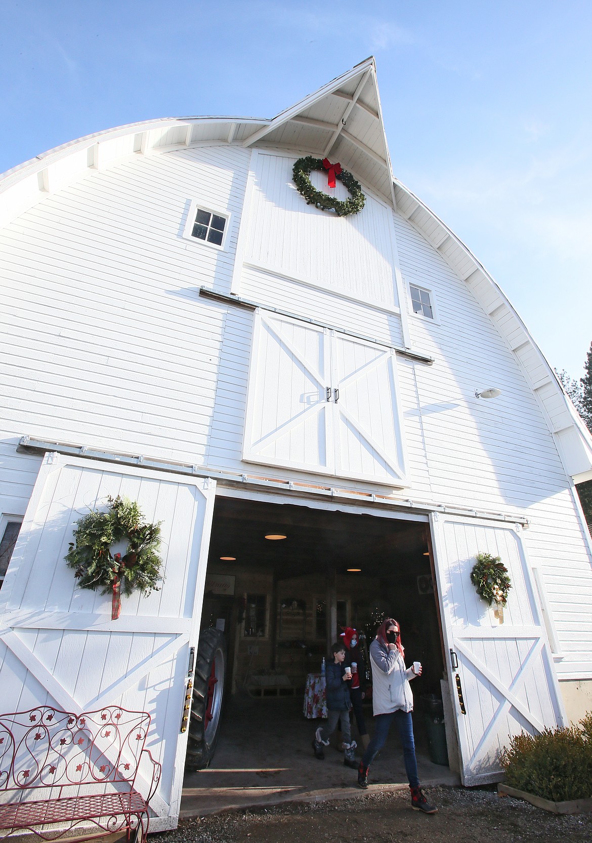 Jen Meier and kids Dylan, 8, and Cecelia, 10, step out of the barn gift shop at Cable Creek Farm during a visit Friday. “It’s a cute farm and they have a decent selection of trees," Jen said.