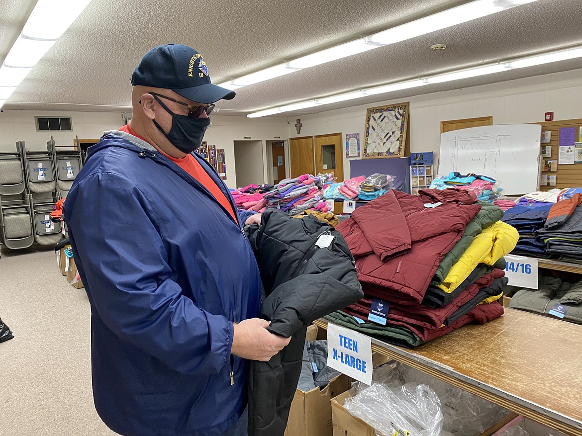 Grand Knight of the St. George Catholic Church Knights of Columbus Jim Burkhardt holds up just one of the 1,000 plus jackets intended to be gifted to children in the Kootenai County area on Friday. (MADISON HARDY/Press)