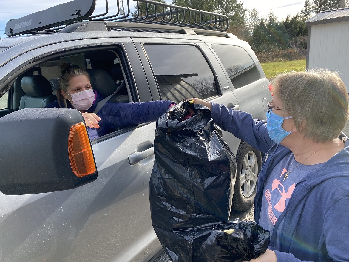 Volunteers at the Knights of Columbus winter coat giveaway passed along tow full trash bags of goodies to Dani Rodriguez that will help dress her kiddos for the cold. (MADISON HARDY/Press)