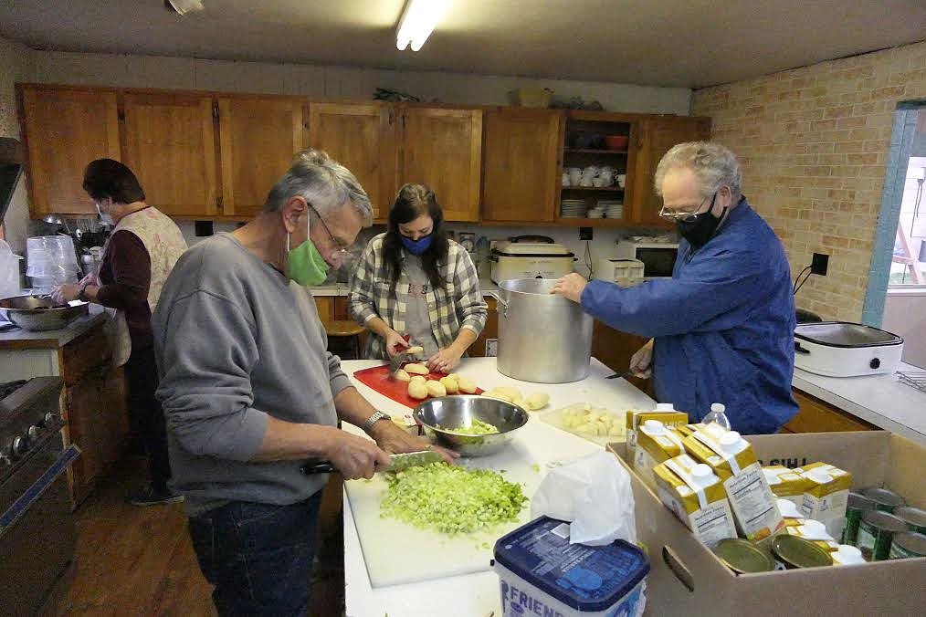 Plains Church on the Move members Bill Albe (gray sweatshirt), Jack Dowell (blue Jacket) and Amber Dimond (center background) chop vegetables during preparation for the Thanksgiving meal. (Chuck Bandel/Valley Press)