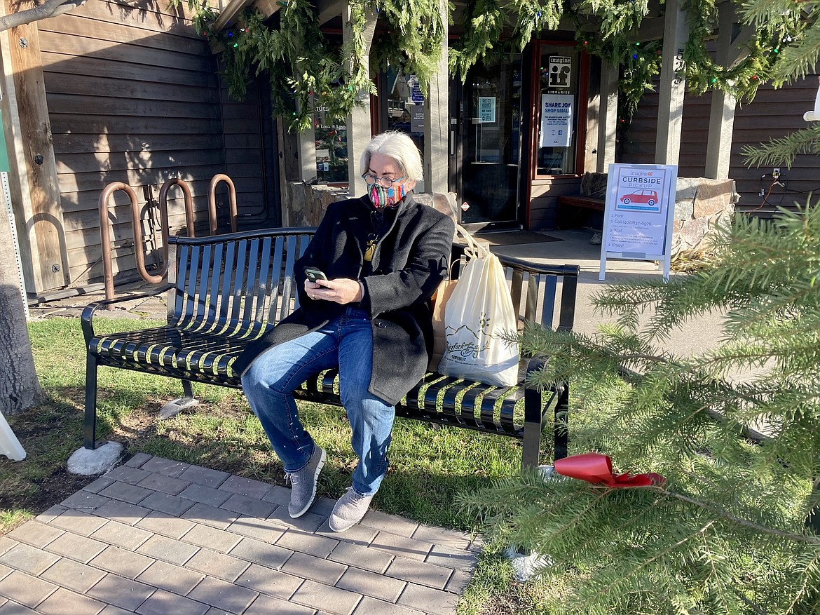 Bret Serbin/For the Eagle
Kathy Steadman rests on a bench with her purchases from Bigfork Bay Gift and Gear.