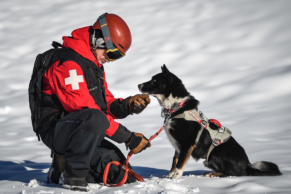 Jett, an avalanche rescue dog with Whitefish Mountain Resort ski patrol, listens to Lloyd Morsett, his owner and snow safety coordinator on the mountain, outside the resort on Wednesday, Dec. 3. Jett was diagnosed with B-cell lymphoma after  Morsett found a lump on Jett’s neck. (Casey Kreider/Daily Inter Lake)