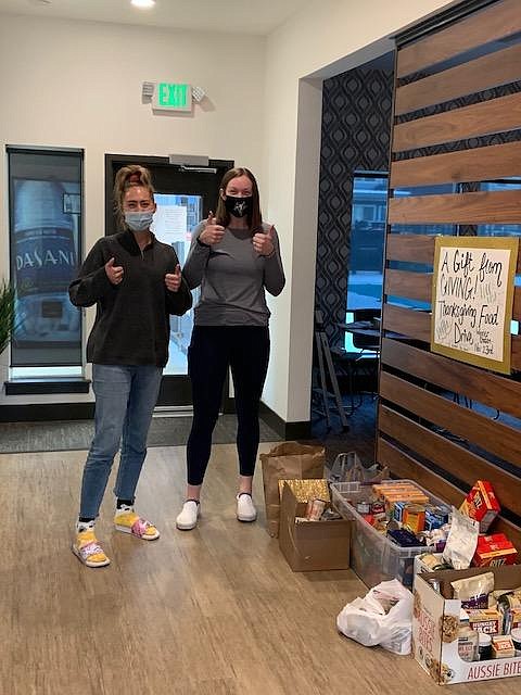 Big Bend Community College volleyball players Ellie Rodgers (left) and Maelyn Mace drop off food donations at the Central Park Apartments office.