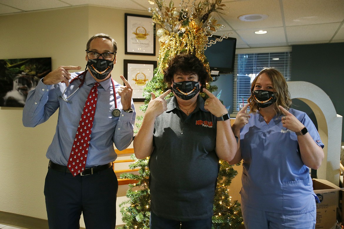 Dr. Geoff Emry, Cheri Hodl (center) and Amber Tatman show off the Smile-4Joe masks that will be given away Dec. 12 in honor of Cheri's late husband, Joe, who died from COVID in August. He was also a great friend of Emry's as well as Tatman's, and countless others in the community.