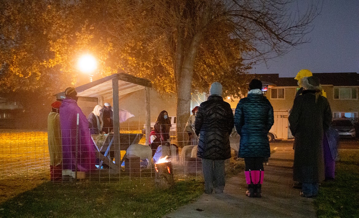 A group stands by listening to the speaker at the final stop of the Living Nativity on Saturday evening, the Nativity Scene, provided by volunteers from the Church of Jesus Christ of Latter-day Saints.