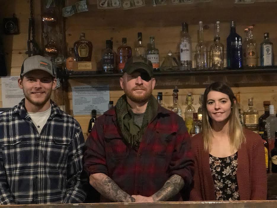 From left, are Tristen Anderson, David Barsotti and Savannah Anderson, whom, along with many volunteers helped make the free Thanksgiving dinner at Bootlegger’s Bar a big success. Tristen and Savannah are the children of bar owners Shannon and Anna Anderson kids. (Monte Turner/Mineral Independent)