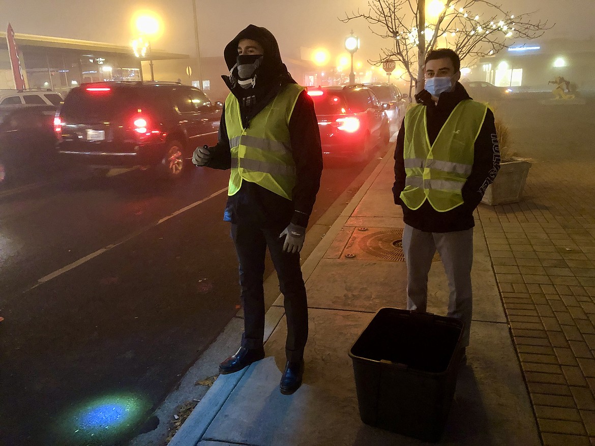 Connor Christiansen (left) and Jakob Peterson (right), both missionaries with the Church of Jesus Christ of Latter-day Saints, stand in Sinkiuse Square Friday evening ready to take donations of food, clothing and toys as part of the Light Up Moses Lake contest and fundraiser.
