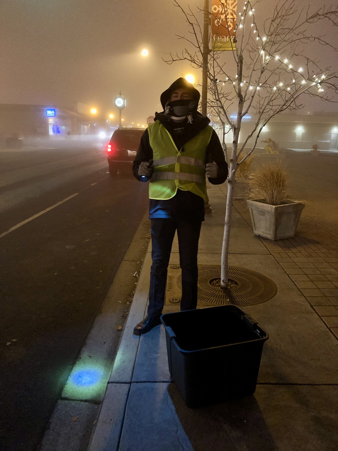 Connor Christiansen, a missionary with the Church of Jesus Christ of Latter-day Saints, stands in Sinkiuse Square Friday evening ready to take donations of food, clothing and toys as part of the Light Up Moses Lake contest and fundraiser.