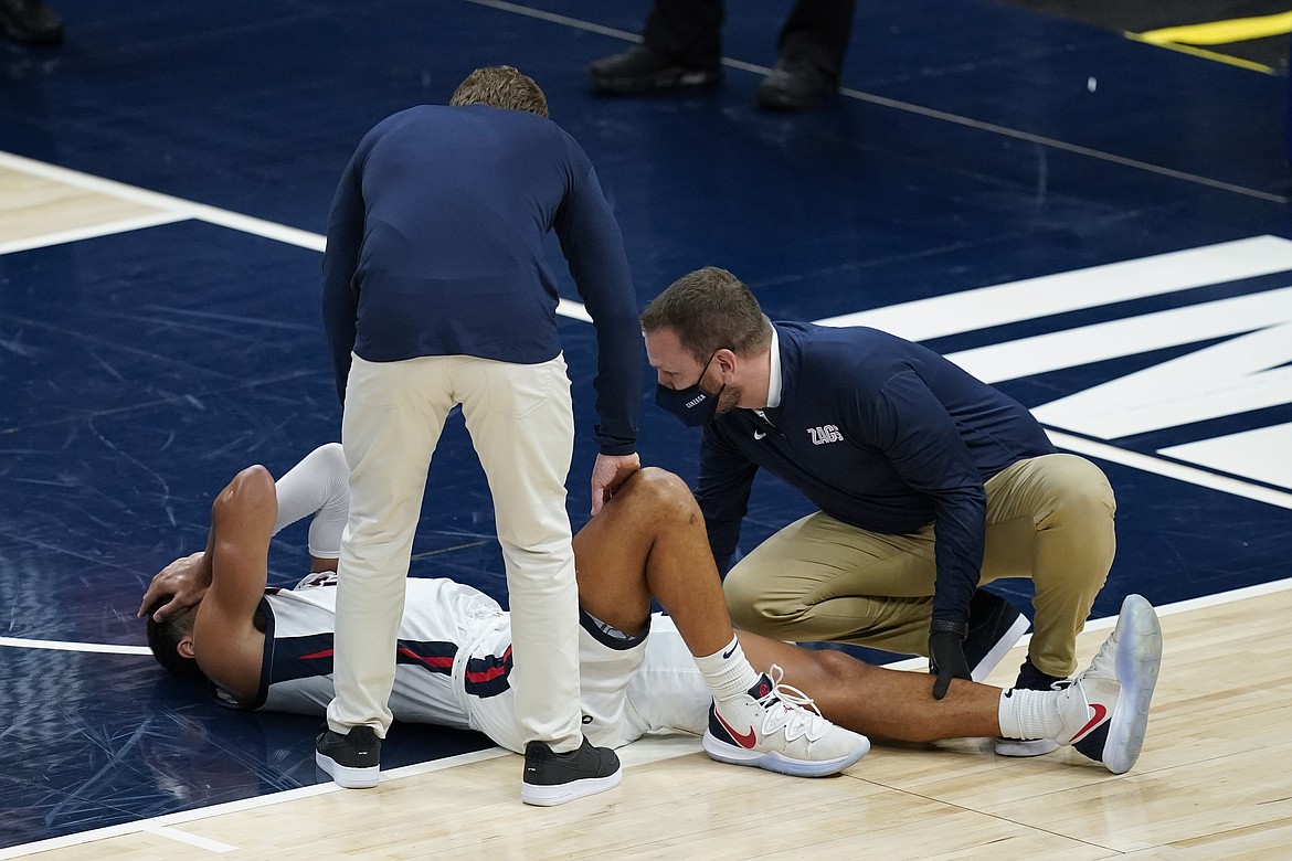 DARRON CUMMINGS
Gonzaga coach Mark Few stands over Jalen Suggs (1) after Suggs injured his left leg during the first half of last Wednesday's game against West Virginia in Indianapolis.