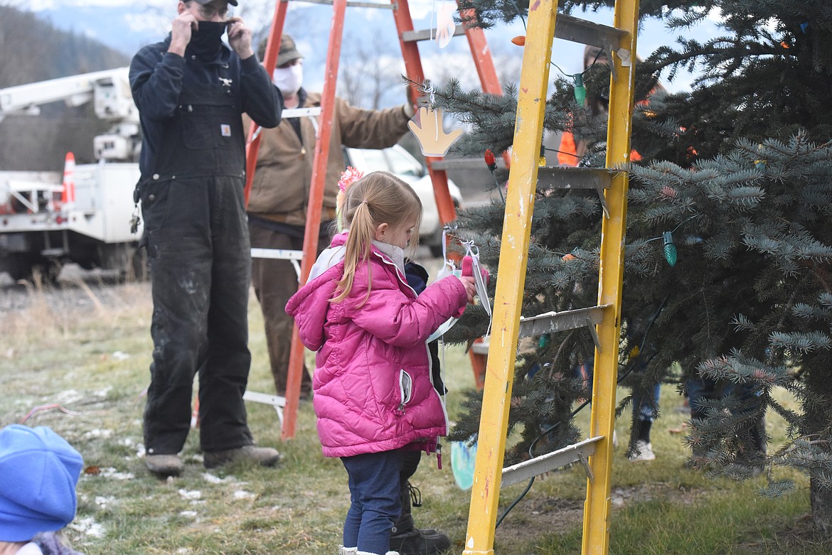 Troy Elementary School student Riley Martin, 5, helps decorate a Christmas tree along Haul Road on Dec. 7. Troy Public Schools and city council coordinated to organize the tree decorating event.