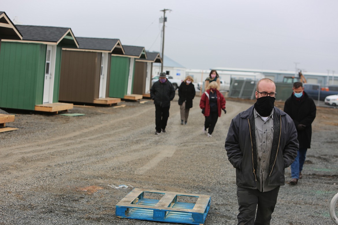 Moses Lake City Council member Don Myers, foreground, and others tour the city’s managed unsheltered camp before it opens Friday night.