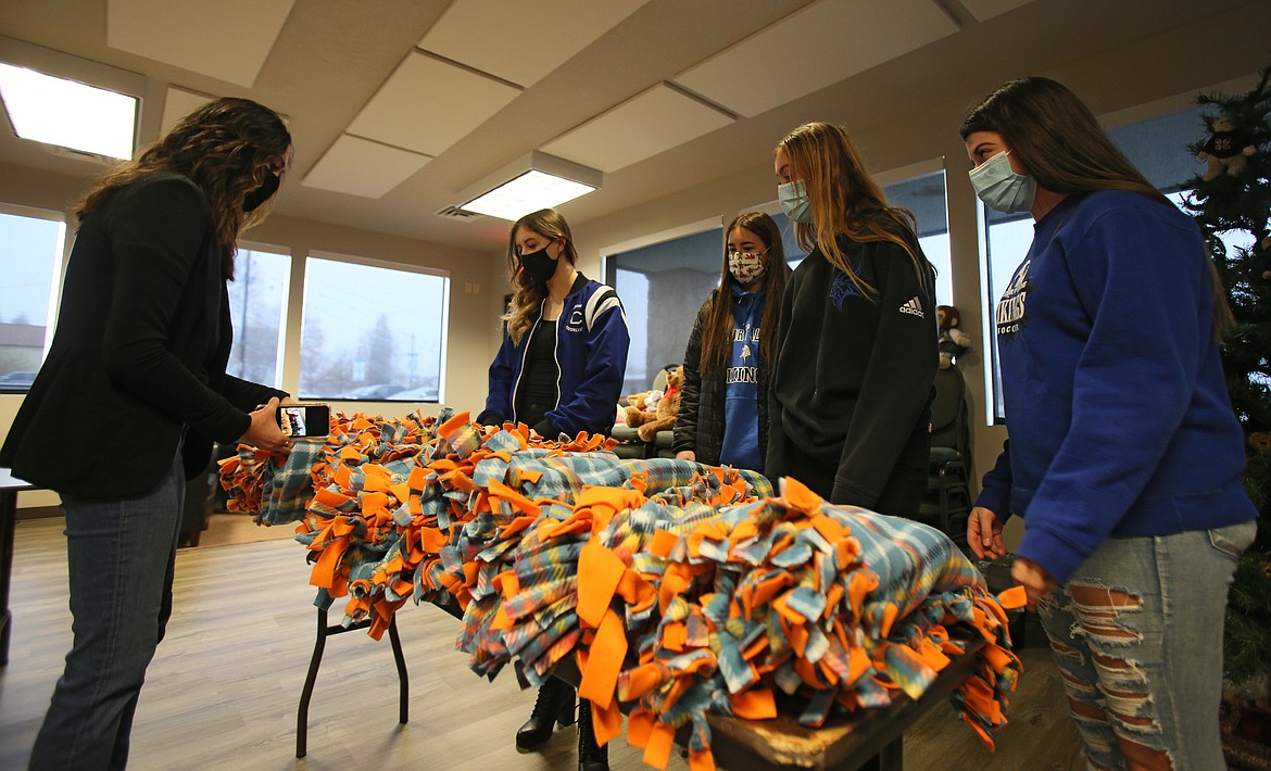 North Idaho CASA development director Kristin Ludwig, left, is presented on Thursday with a gift of 12 hand-tied blankets made by Coeur d'Alene High juniors. Also pictured, from right: Ellie Morrisroe, Myah Rietze, Amy Corette and Rachel Gourley.