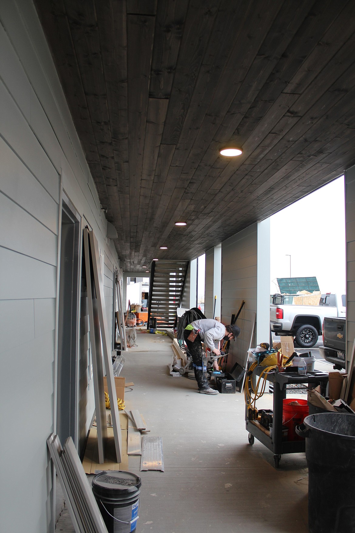 Zach Weiss readies flooring outside one of the two new apartment buildings of The Gateway, 5025 N. Owens Road, in Moses Lake. The first phase, with two buildings of 15 units each, began in March and will be completed in early 2021. However, one of the buildings is complete and already has renters. The second phase, with another two buildings of the same size, will begin in January.