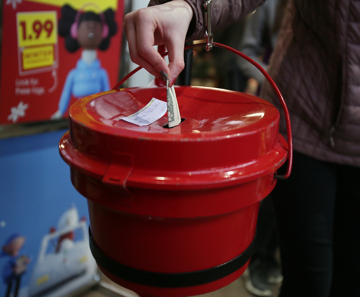 A generous Fred Meyer patron on Thursday drops a $1 bill into a Salvation Army Red Kettle at Fred Meyer. The Rescue Christmas Red Kettle campaign is not quite to three-quarters of its fundraising goal and is behind where it was this time last year.