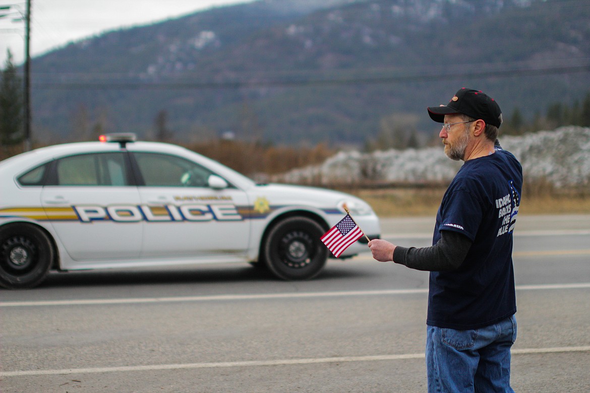 Darren Thompson salutes first responders as they pass by Thursday afternoon on Highway 200. “I didn’t know [Victorino] personally, but I wanted to support them," he said.