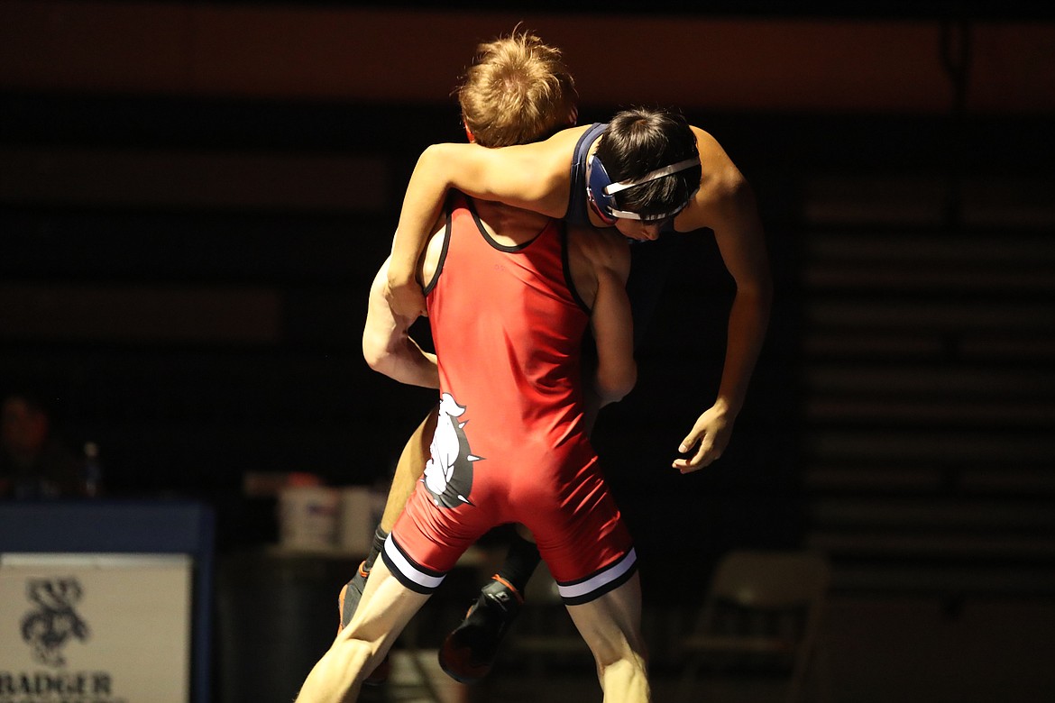 Senior Tanner Dickson picks up Ravi Neumeyer from Bonners Ferry during a 120-pound bout Thursday.