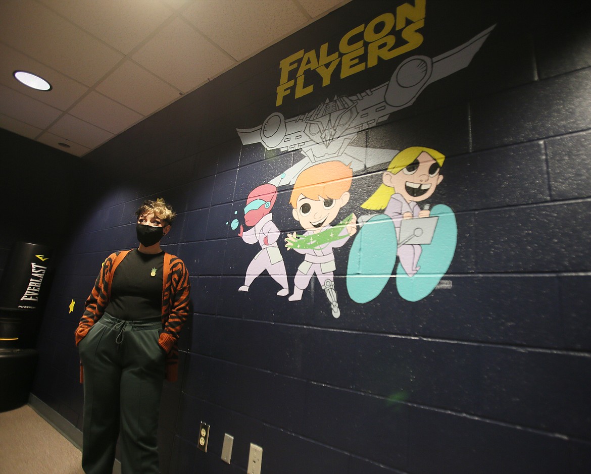 Digital artist Bre Gotham on Thursday stands next to a mural she painted in the Falcon Flyers Room in Fernan STEM Academy. Gotham, Mountain West Bank, Sherwin Williams and the Coeur d'Alene School District collaborated to upgrade the space-themed sensory room, which was completed in October.