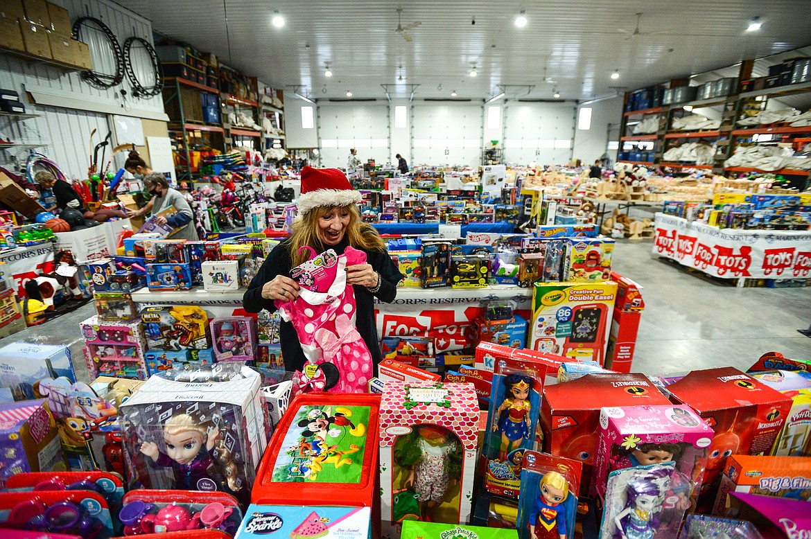 Volunteer Mitzi Carpenter sorts and displays items at the Flathead County Toys for Tots distribution warehouse at The Party Store on Saturday, Dec. 12. (Casey Kreider/Daily Inter Lake)