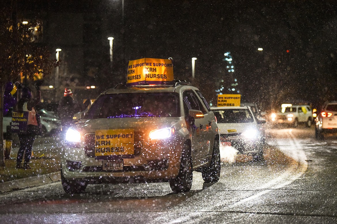 Drivers and passengers honk horns and wave signs as they participate in a Solidarity Drive car caravan for a fair contract for Logan Health registered nurses outside Kalispell Regional Medical Center on Friday, Dec. 11. (Casey Kreider/Daily Inter Lake)