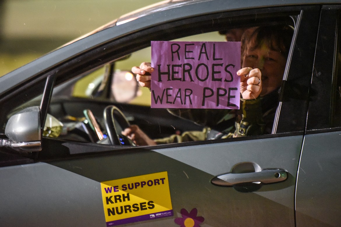 Drivers and passengers honk horns and wave signs as they participate in a Solidarity Drive car caravan for a fair contract for Logan Health registered nurses outside Kalispell Regional Medical Center on Friday, Dec. 11. (Casey Kreider/Daily Inter Lake)