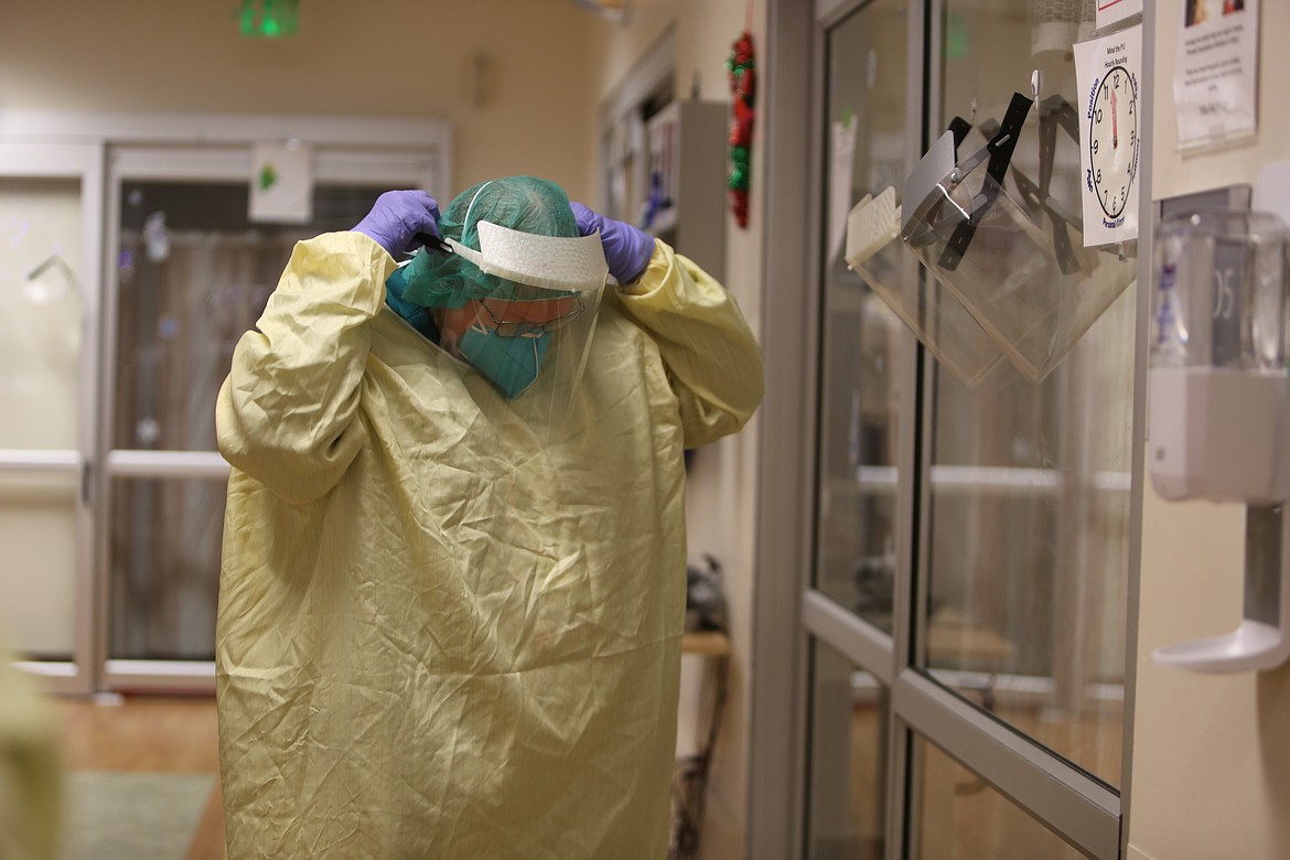 Registered Nurse Sandy Martin dons a face shield before entering one of Samaritan Hospital's Intensive Care Unit rooms, each of which are separated from the others and have been converted into negative pressure rooms, which keeps air from flowing back into the rest of the hospital.