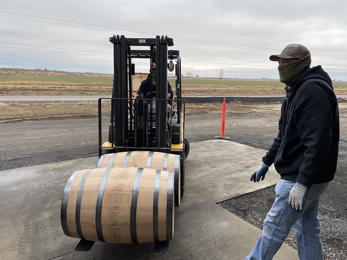 Woodinville Whiskey Co. warehouse workers load barrels of whiskey.