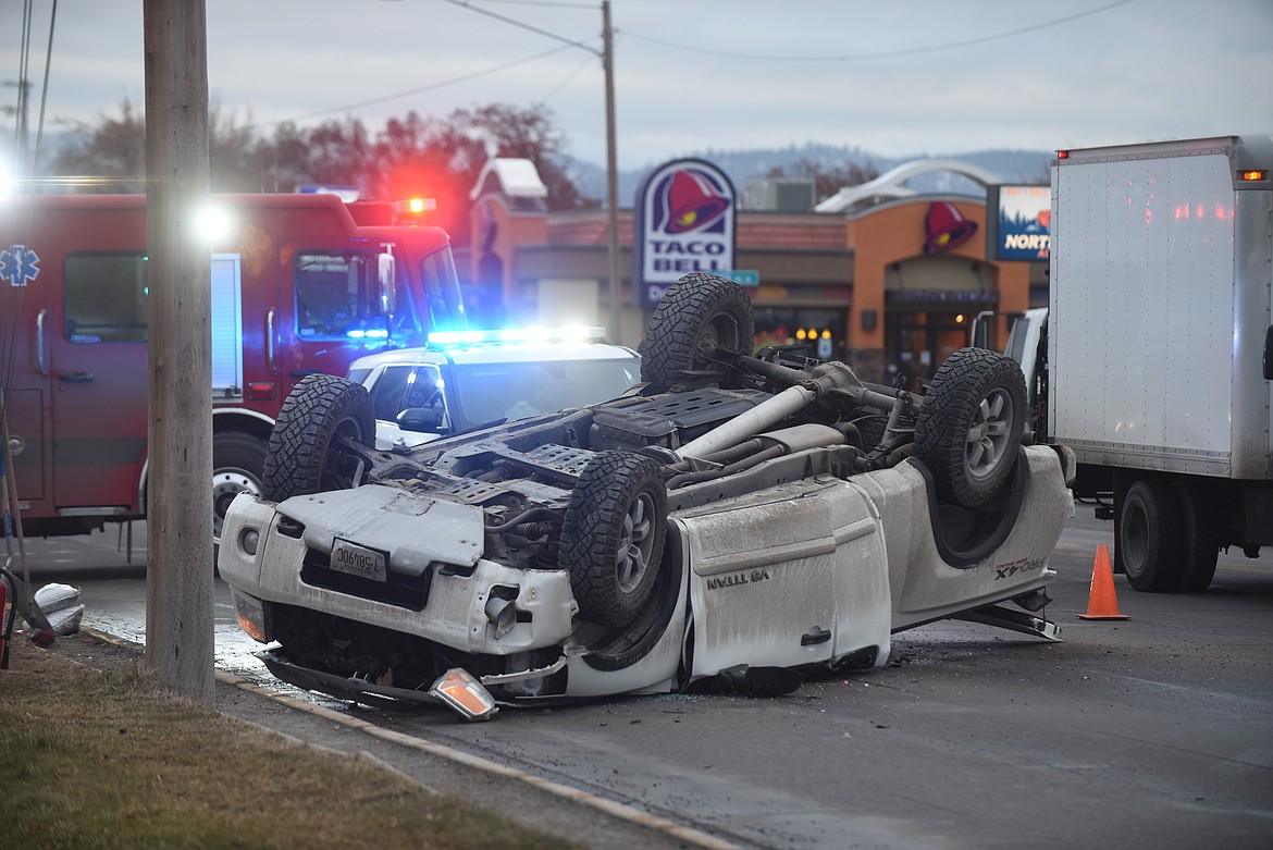 A Nissan Titan pickup truck rests on its roof Monday afternoon after it hit a pole and flipped on E. Idaho St. in Kalispell. According to Kalispell Police Sergeant Chad Feitveit, the local man driving the truck was wearing his seat belt and was responsive when he was taken to Kalispell Regional Medical Center. The cause of the accident was not immediately known. (Scott Shindledecker/Daily Inter Lake)