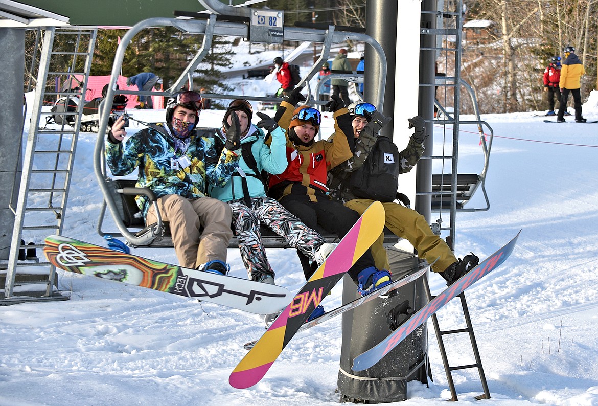 Excited snowboarders load a chair on Whitefish Mountain Resort's opening day Thursday. (Whitney England/Whitefish Pilot)