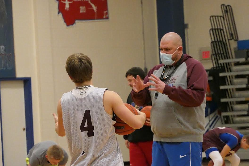 Clark Fork boys basketball coach Erik Johnson works with returning point guard Bryan Mask during practice last week. (Chuck Bandel/Valley Press)