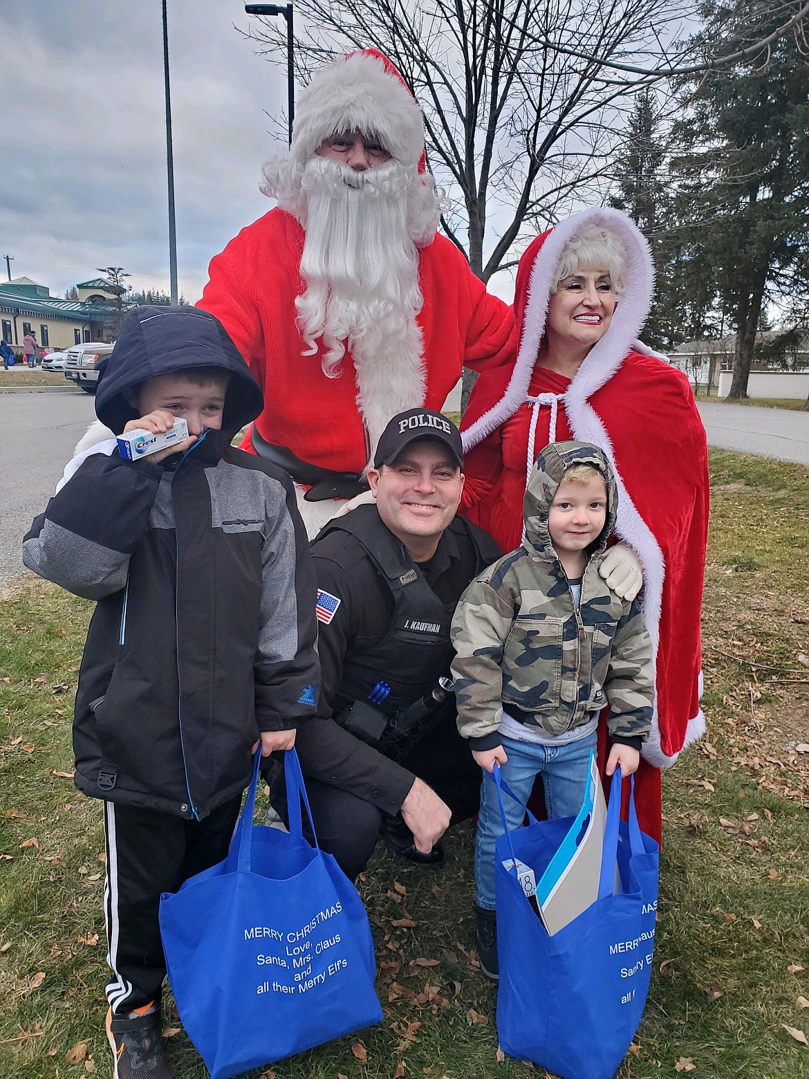 Santa, Mrs. Claus and Officer Joe Kaufman pose for a photo with children Saturday in Ponderay.