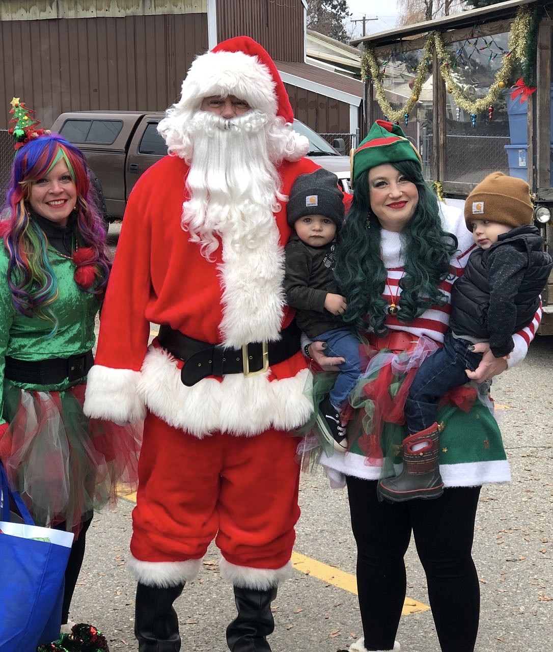 Santa and his elves pose for a photo with children on their route Saturday in Ponderay.
