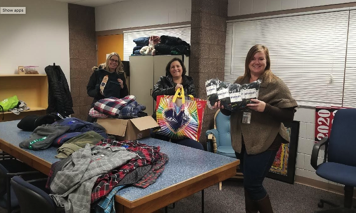 Venture High School counselor Rachelle Smotherman, right, accepts donations of new Bombas socks and other clothing from Coeur Closet coordinators Polly Melendez, far left, and Paula Lyon on Monday. Coeur Closet is a nonprofit that provides clothing and other personal items for North Idaho students in need.