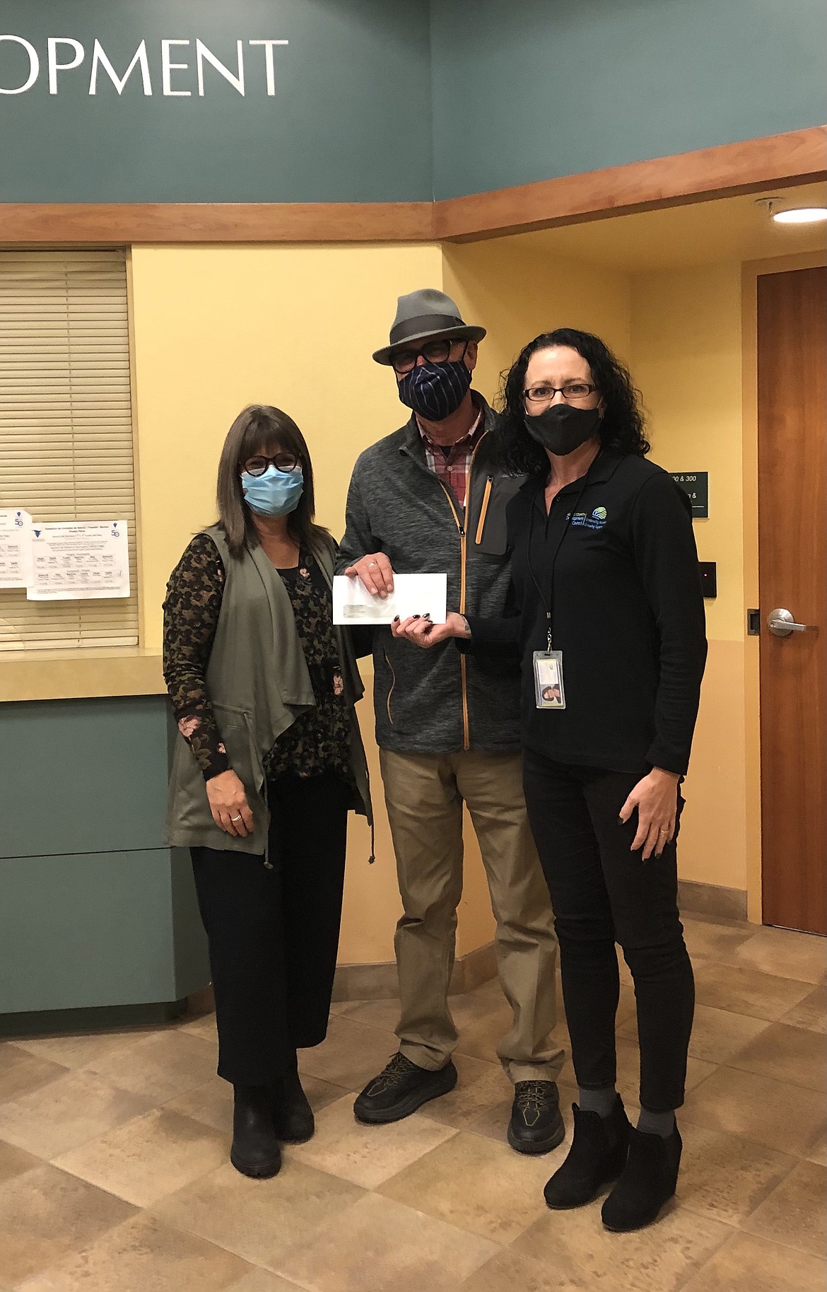 Janis Rountree, manager of the Adams County Economic Development Council (right) presents a check from the Adams County CARES Act small business grant program to Lori and Timm Taff, of the Conversatio Coffee Roasters, Othello.