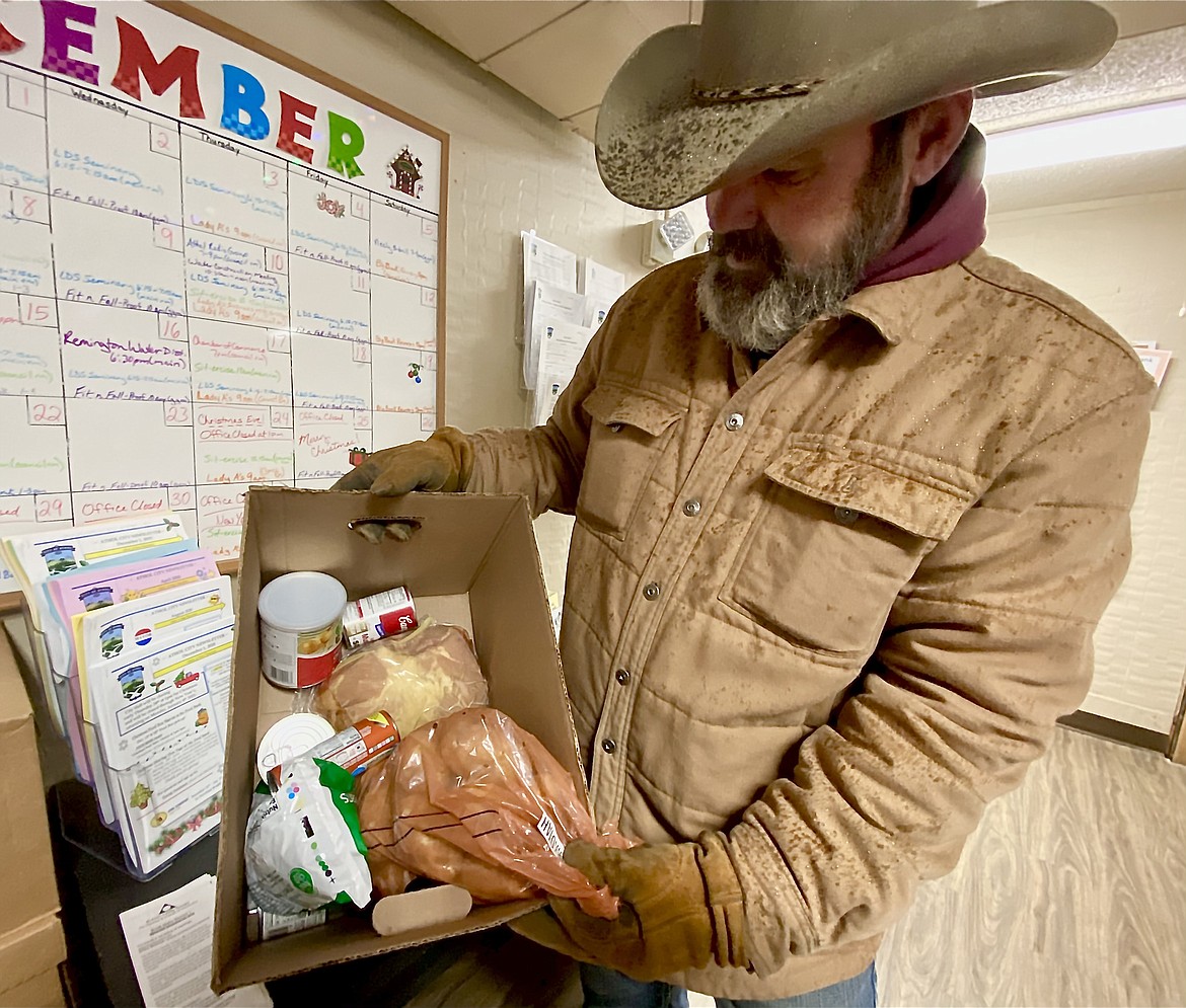 Charles Lounsbury, a day volunteer with Farragut Storage, packs up one of the 60 boxes of food donated by the Klinge family through the Joshua Brandt Foundation Tuesday at the ABC Food Bank. (MADISON HARDY/Press)