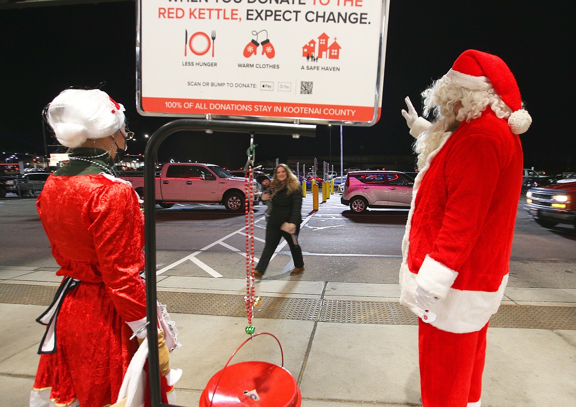 Rick Rasmussen, playing Santa Claus, and Ann Thomas, playing Mrs. Claus, greet customers outside Super 1 in Coeur d'Alene Wednesday night.