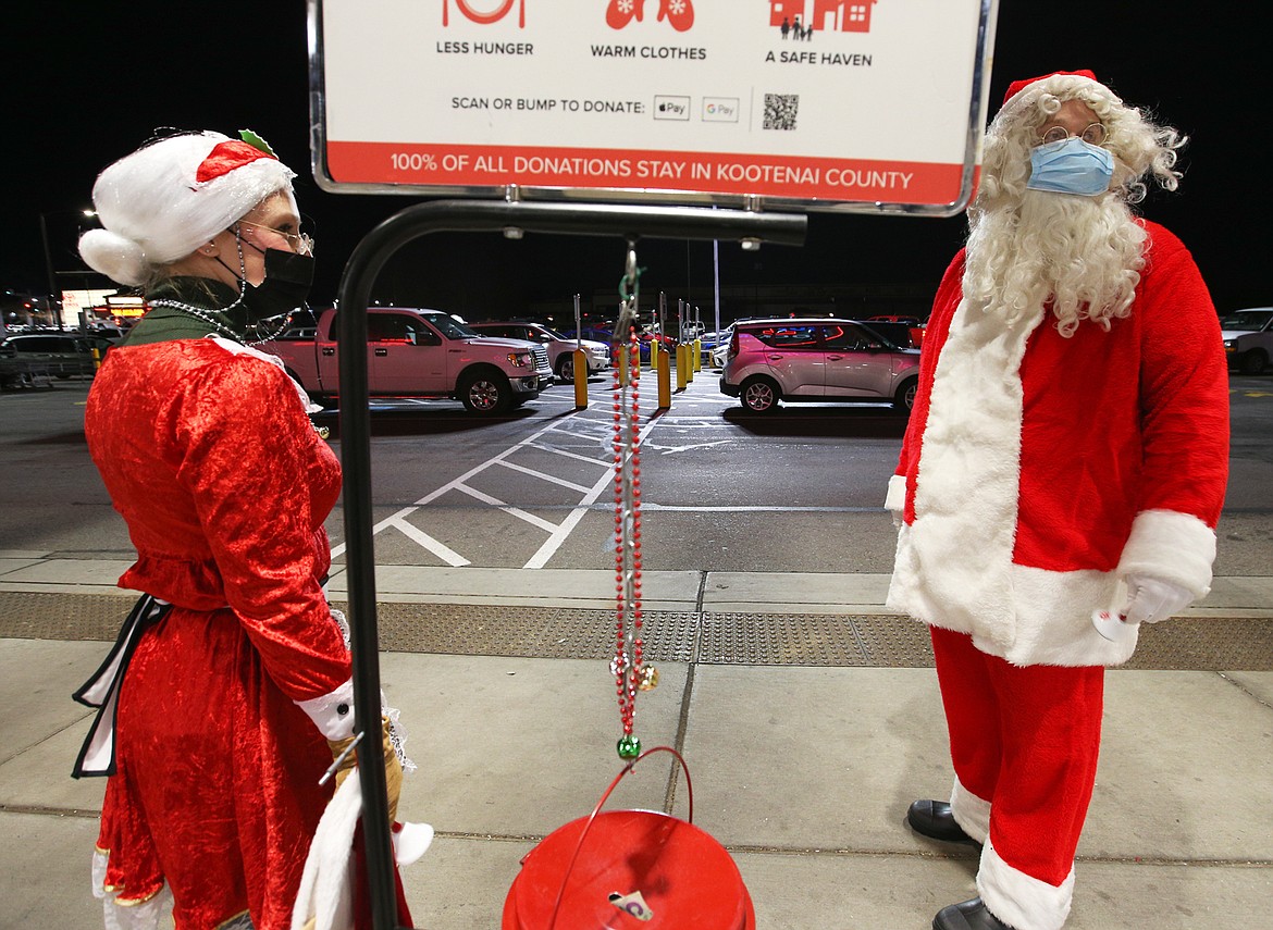 Rick Rasmussen, playing Santa Claus, and Ann Thomas, playing Mrs. Claus, greet customers outside Super 1 in Coeur d'Alene Wednesday night.