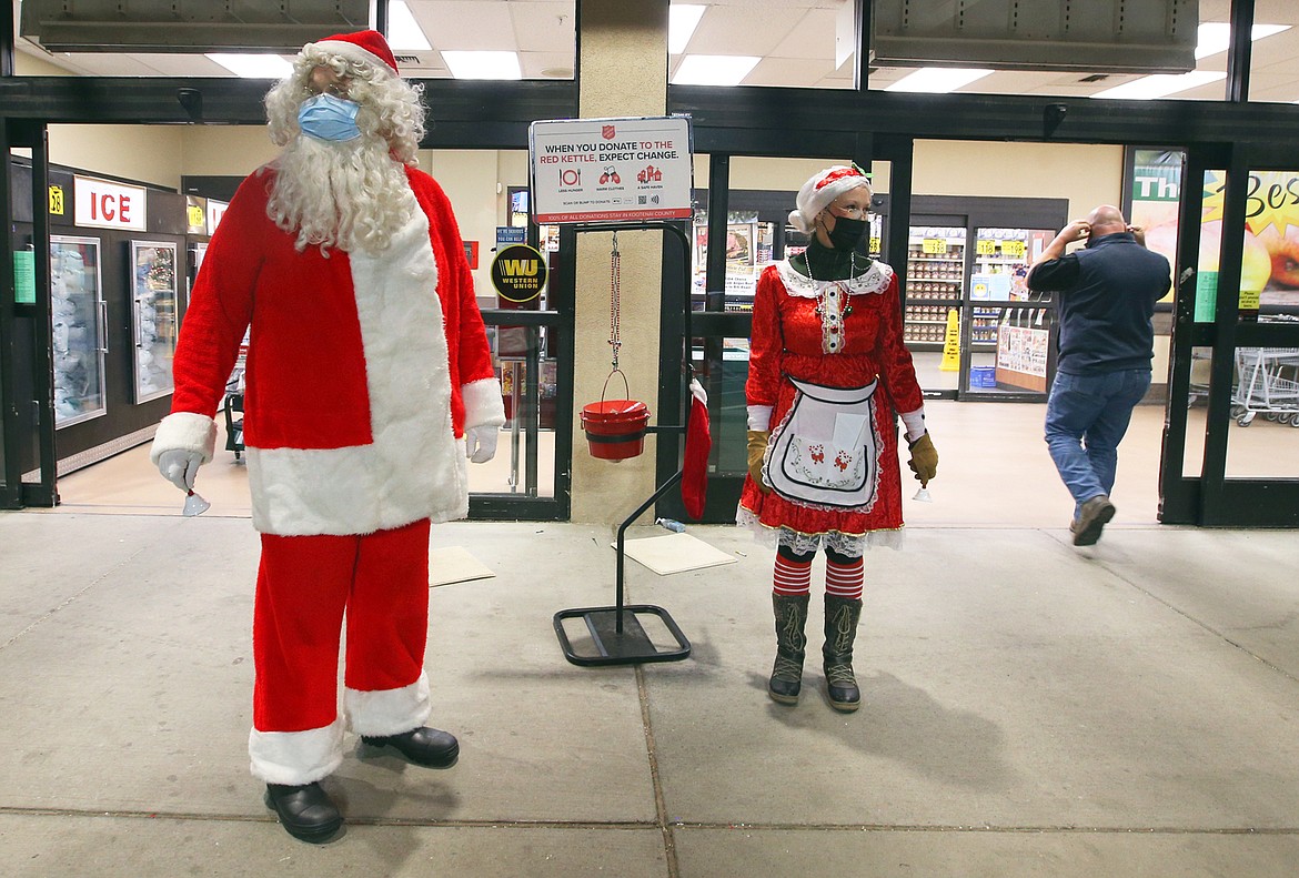 Rick Rasmussen, playing Santa Claus, and Ann Thomas, playing Mrs. Claus, greet customers outside Super 1 in Coeur d'Alene Wednesday night.