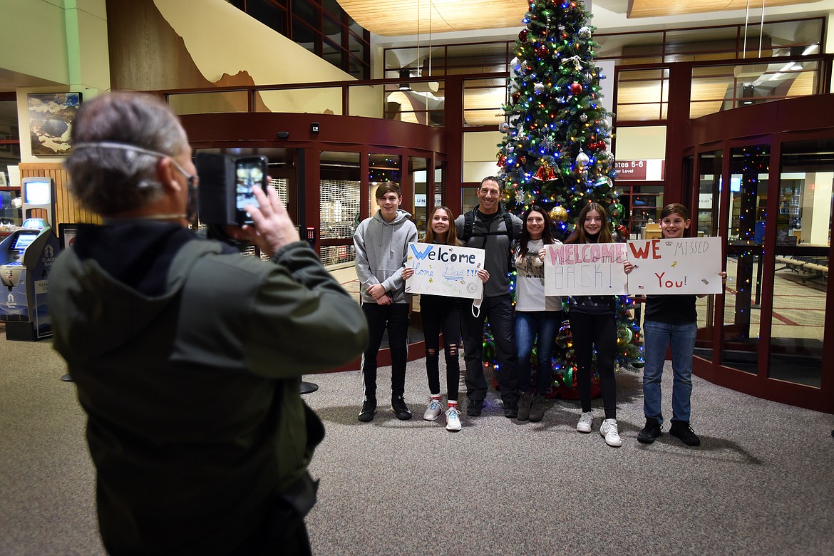 Colby Lenz and his family pose for a quick family photo at Glacier International Airport early Friday morning after Lenz returned home from a 13-month deployment in East Africa with the Navy. (Jeremy Weber/Daily Inter Lake)