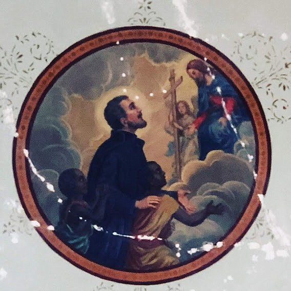 The 6-foot St. Peter Claver medallion on the Mission Church ceiling. Plaster cracks and screw holes made during the repair process have been filled. Old varnish was removed and then paint colors were matched as closely as possible as it was repainted with a dry fresco method similar to that used originally.
