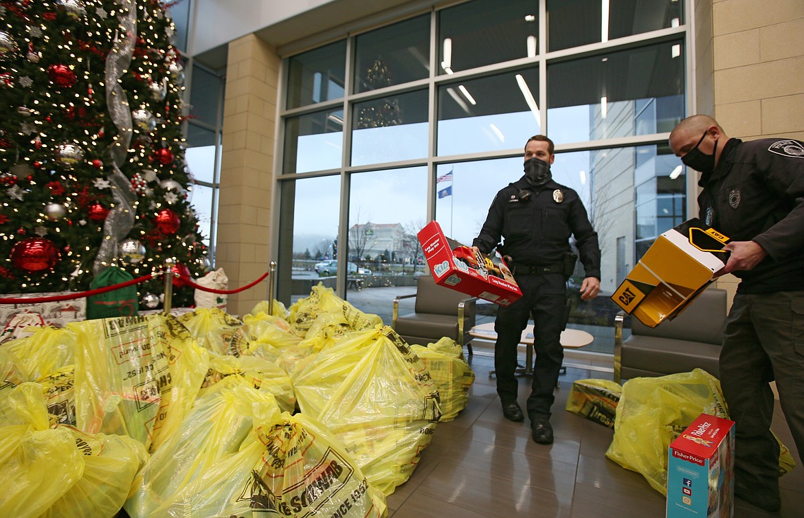 Coeur d'Alene Police Officer Caleb Hutchison, left, and Sgt. S.C. Avriett arrange toys in the lobby of Kootenai Health on Friday during a drop-off for the Coeur d'Alene Police Foundation Children's Hospital Toy Drive.