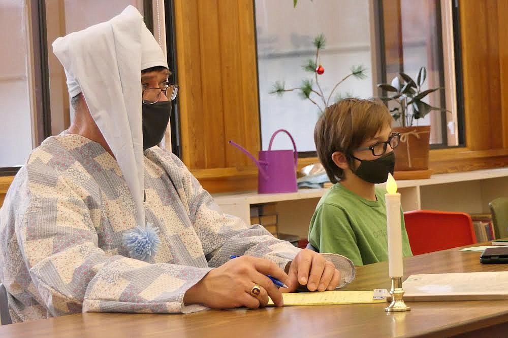 Plains School Superintendent Thom Chisholm, AKA “Ebenezer Scrooge,” listens to a charity presentation while seventh grader Kalem Ercarbrack takes it all in. Ercarbrack's presentation was about battling leukemia. (Chuck Bandel/Valley Press)