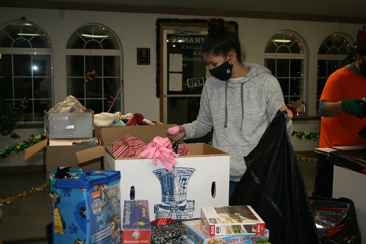 Lena Jenson (back) and Alexandra Monroy choose toys for distribution to kids as part of the Othello Christmas basket project.