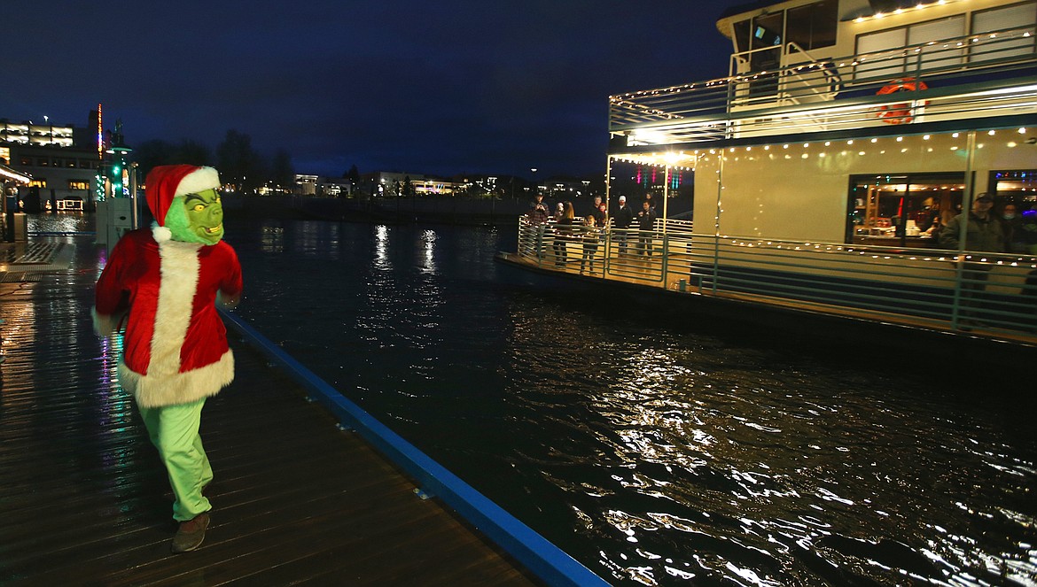 The Grinch marches along with a Lake Coeur d'Alene Cruises boat as it heads out on a holiday lights trip to the North Pole.